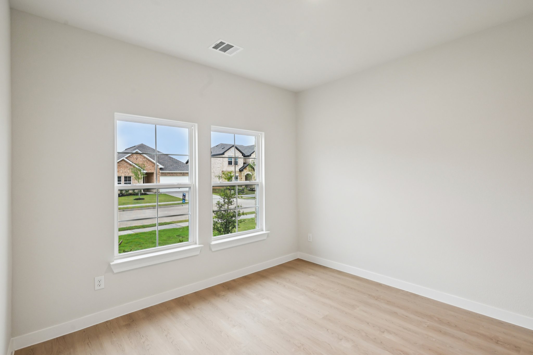A room with a window and a wood floor.