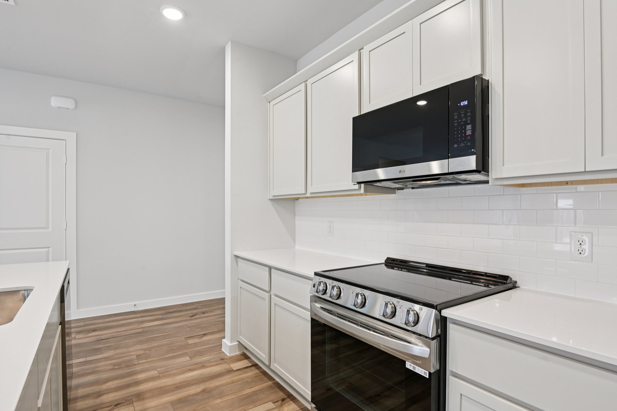 A kitchen with white cabinets.