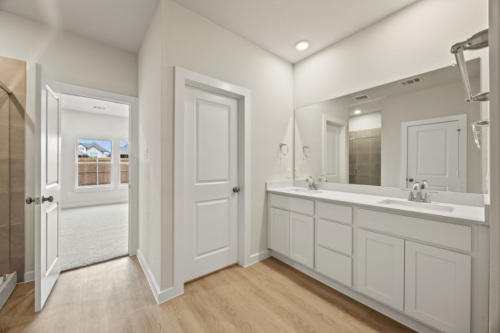 A bathroom with white cabinets.