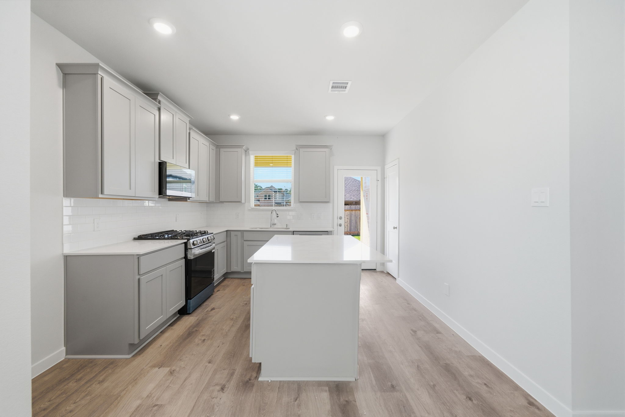 A kitchen with white cabinets.