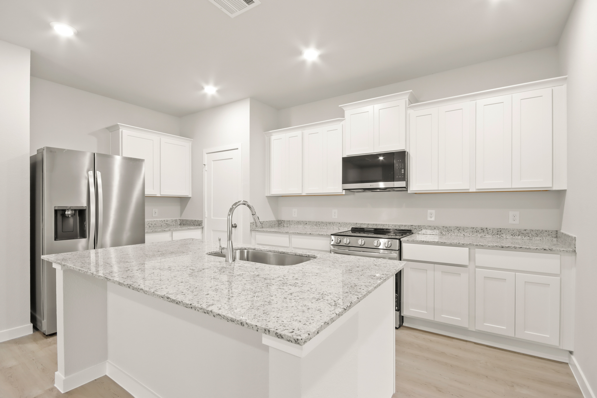A kitchen with white cabinets.