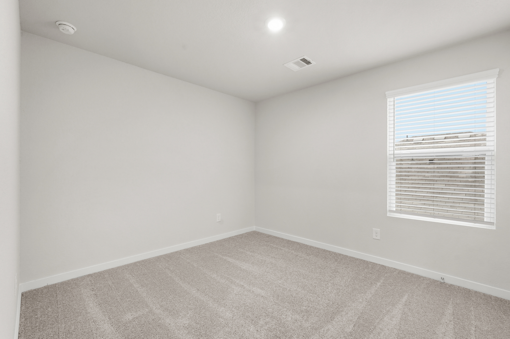 A room with a window and a carpet.