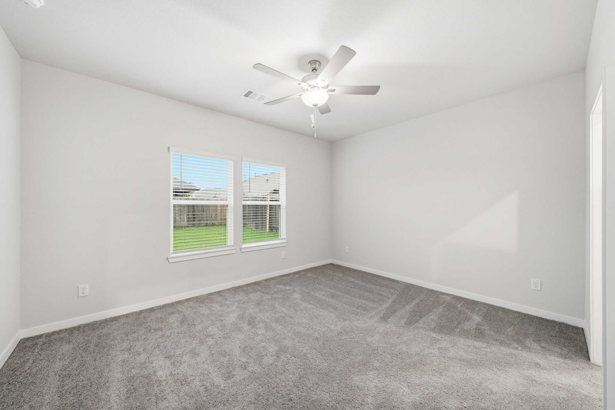 A room with a ceiling fan and a window.