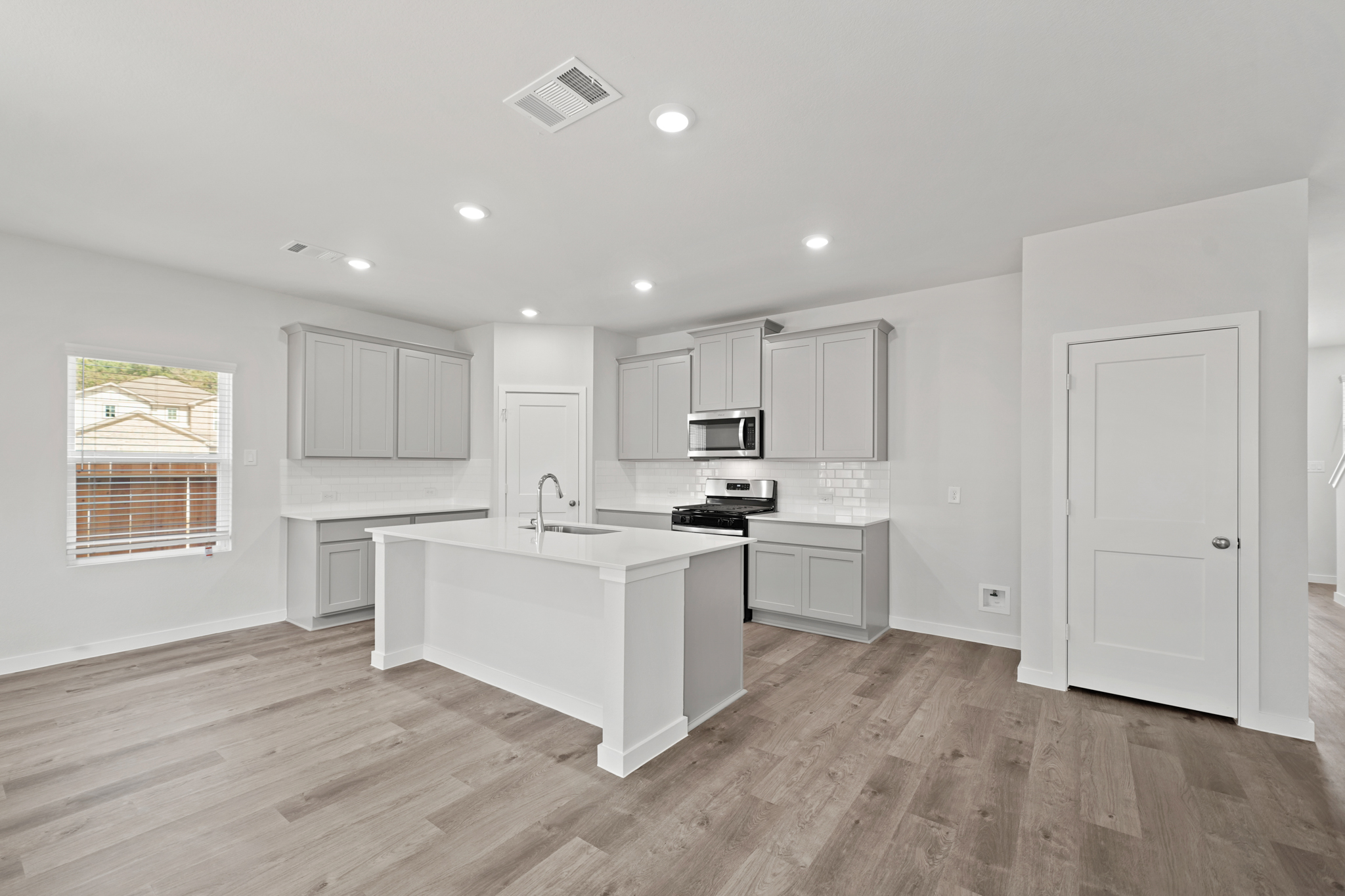 A kitchen with white cabinets.