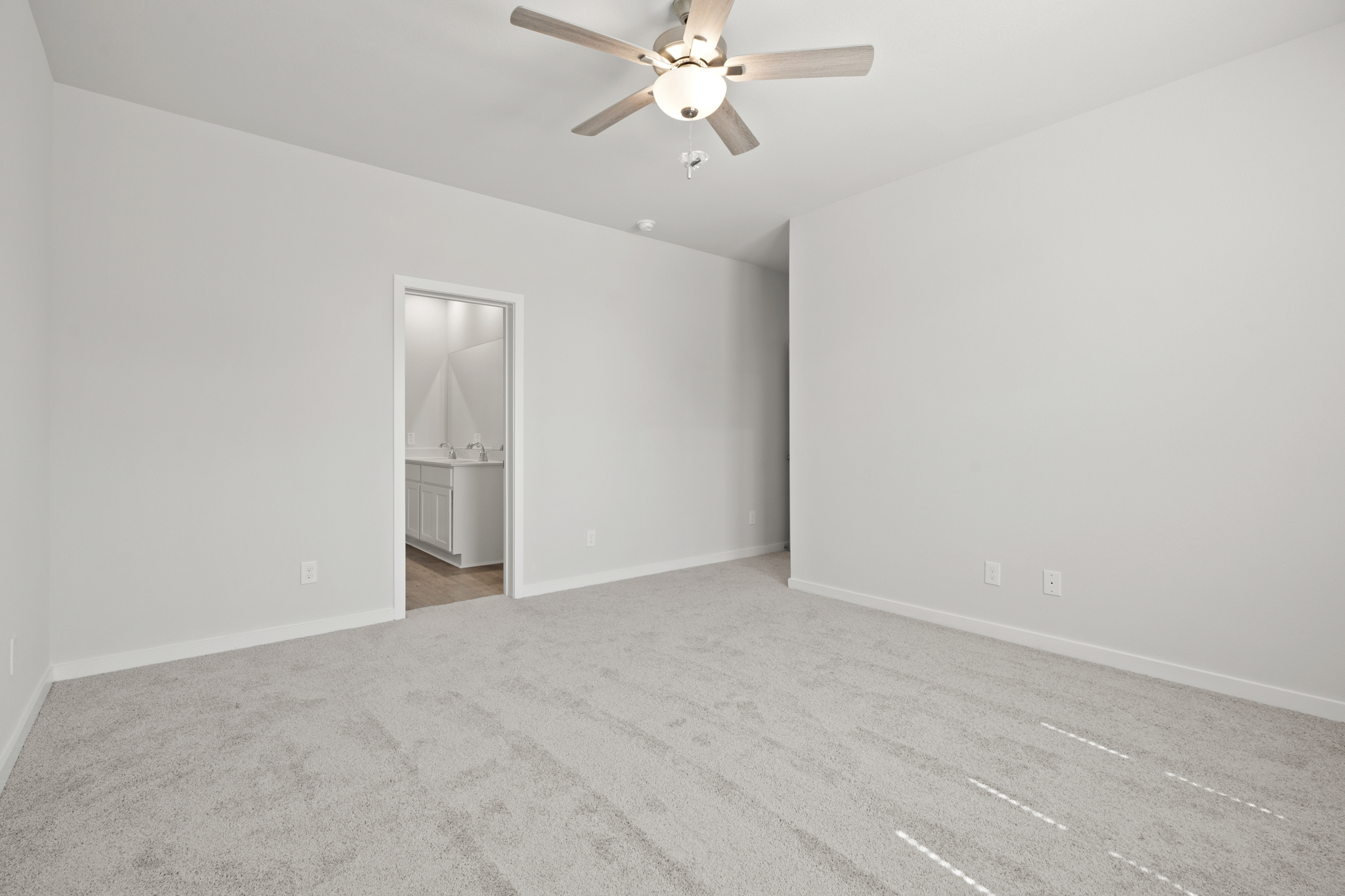 A room with a ceiling fan and a door.