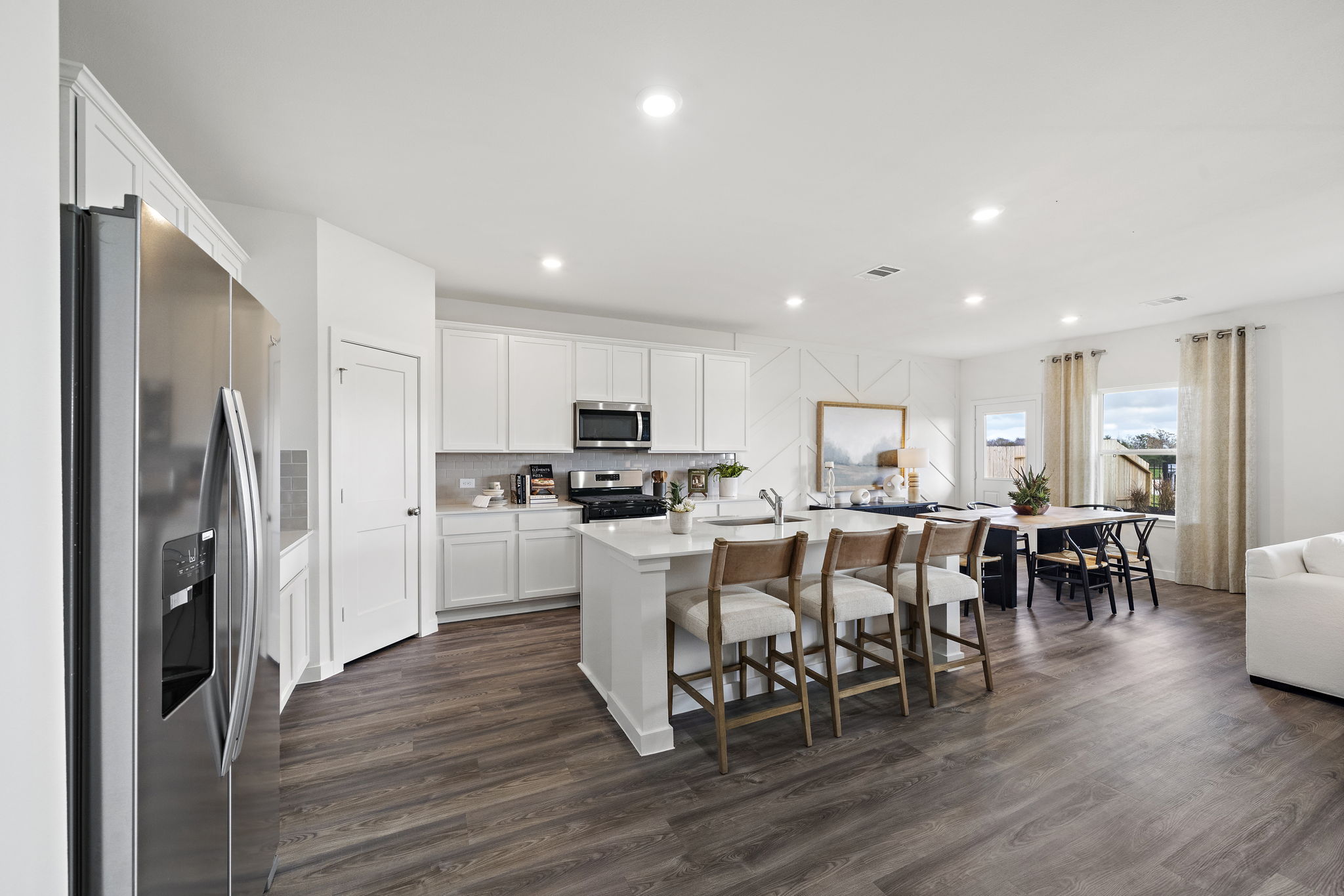 A kitchen with a dining table and chairs.