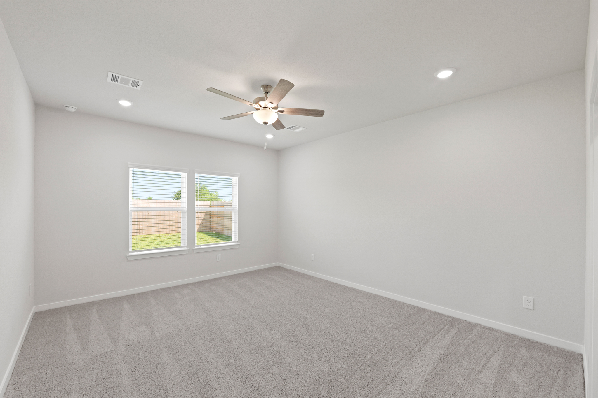 A room with a ceiling fan and a window.