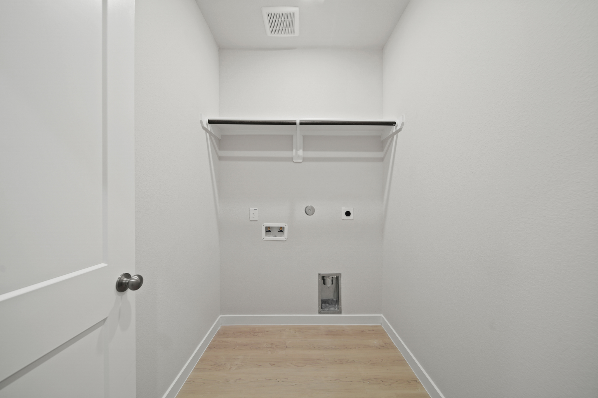 A white room with a wood floor.