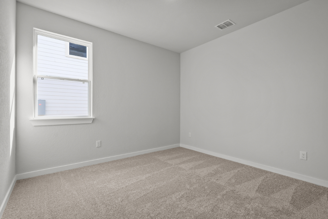 A room with a window and a carpet.