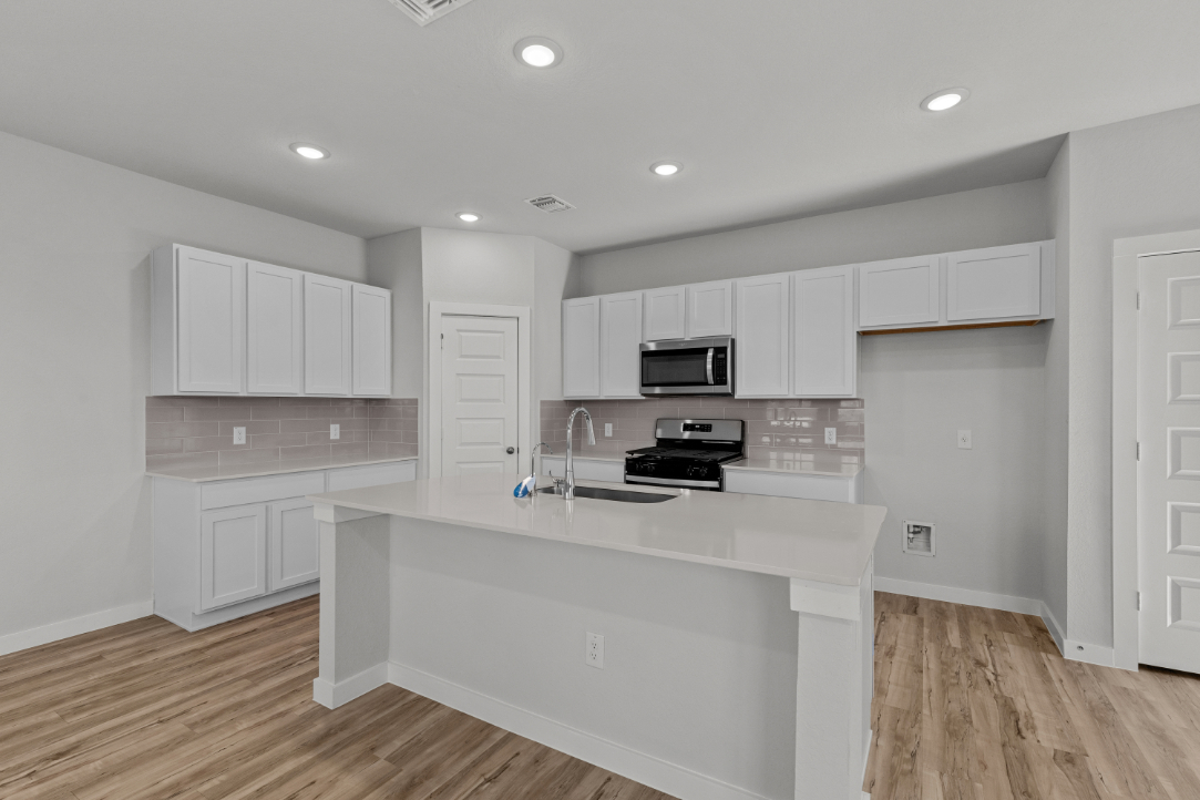 A kitchen with white cabinets.