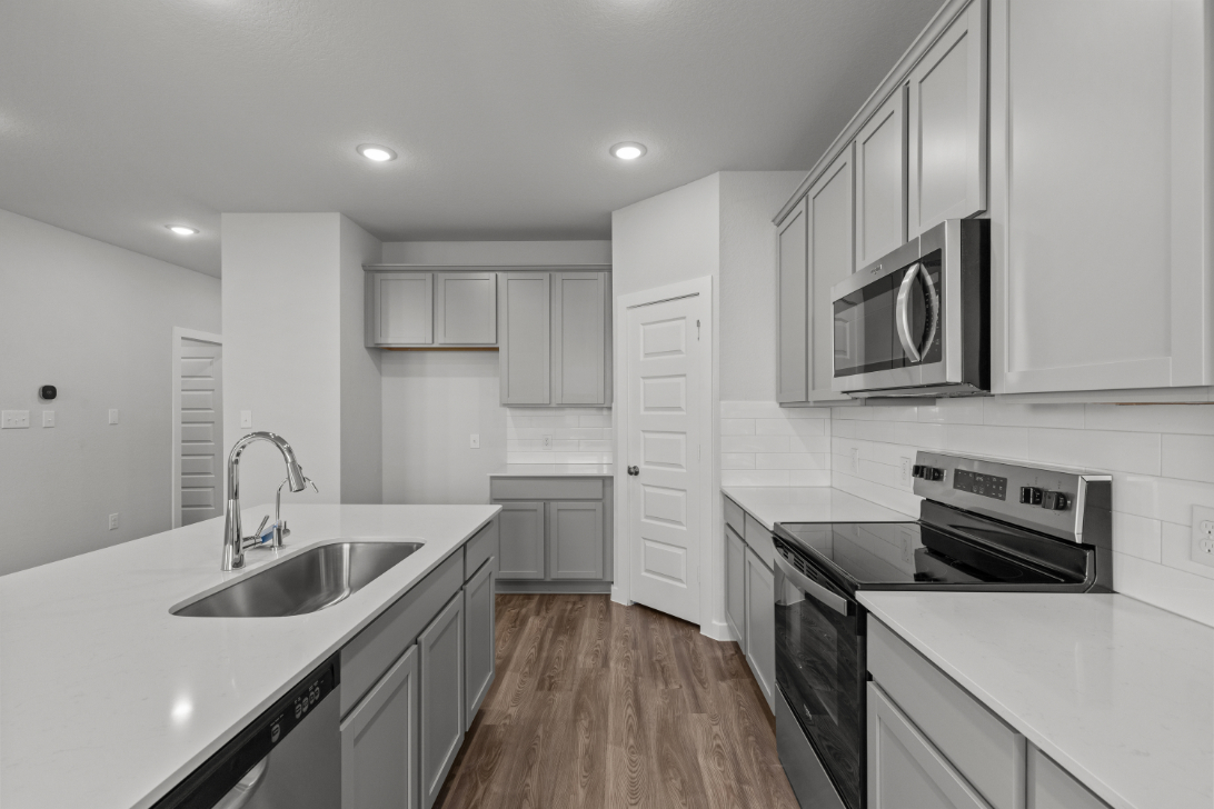A kitchen with white cabinets.