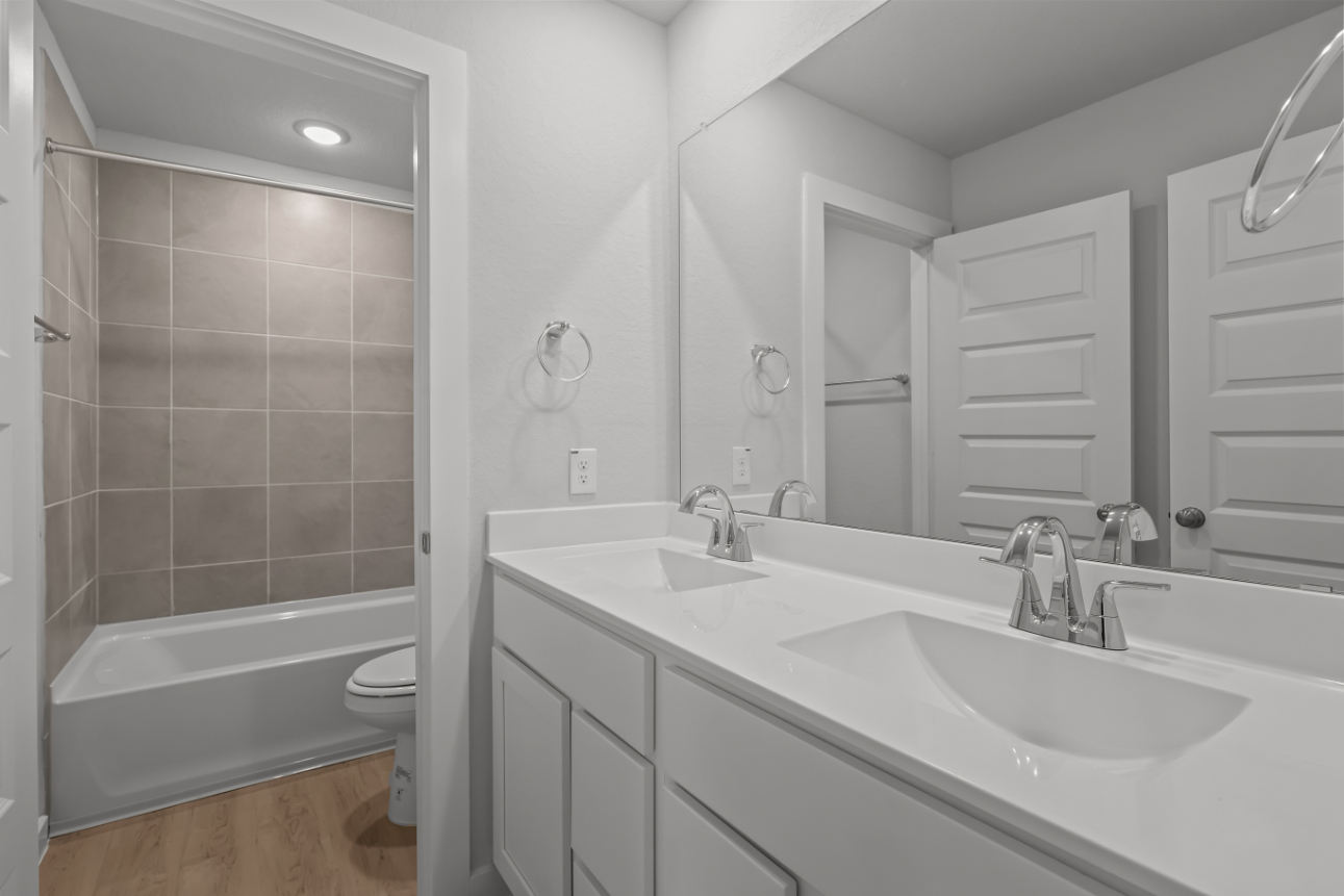 A bathroom with a tub sink and toilet.