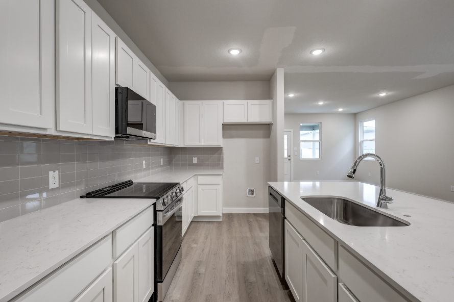 A kitchen with white cabinets.
