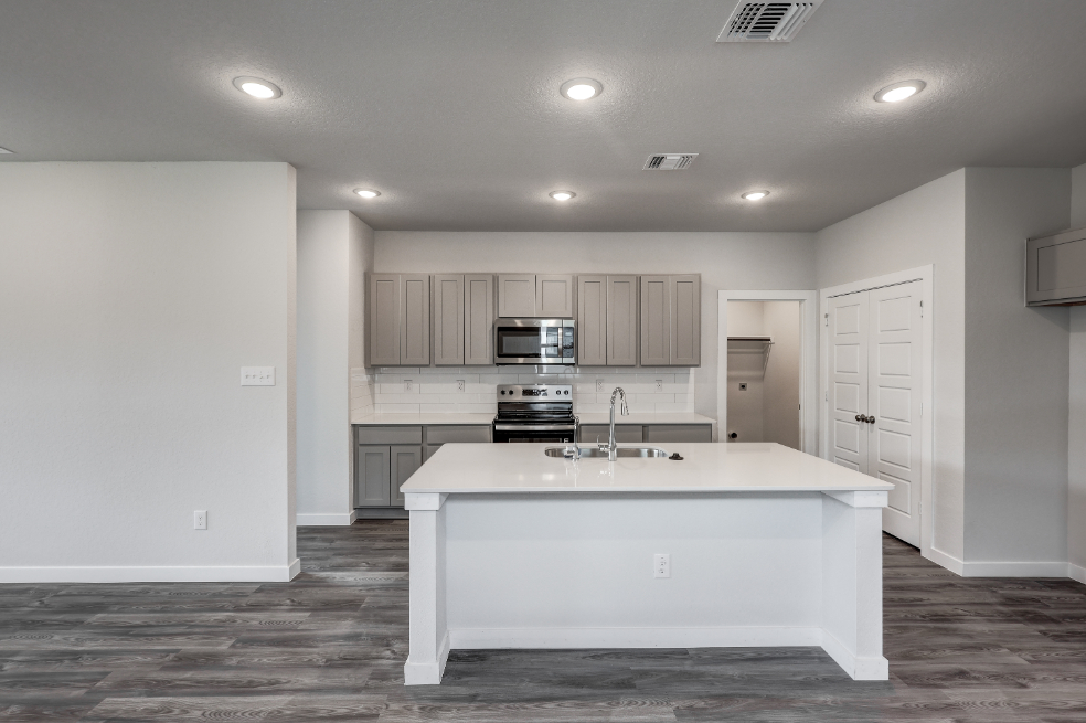 A kitchen with white cabinets.