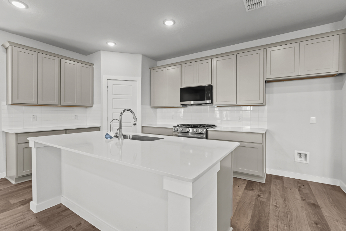 A kitchen with white cabinets.