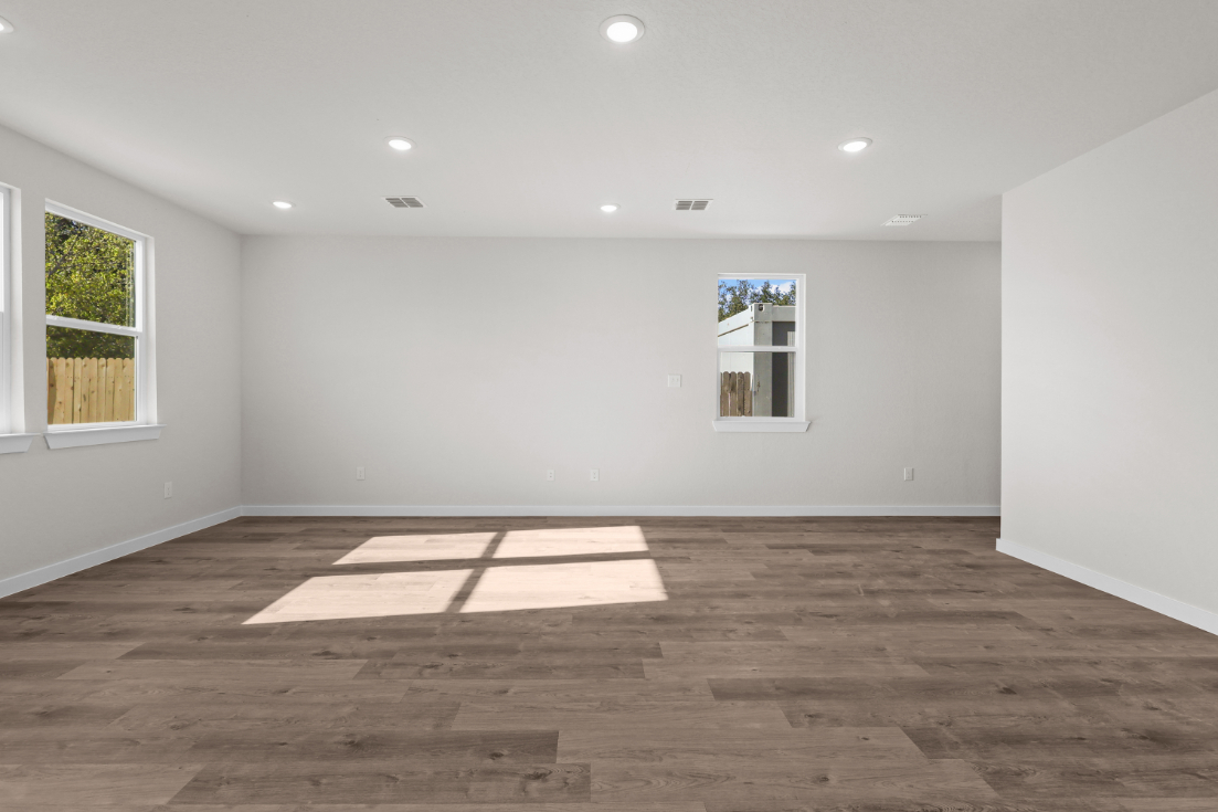 A room with a wood floor and windows.