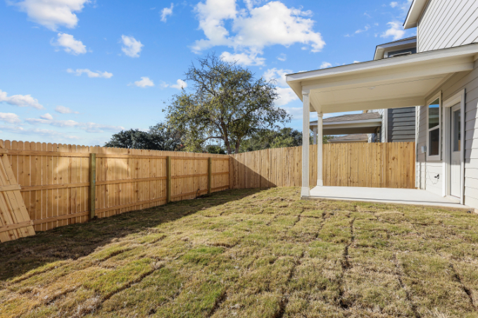 A fenced in yard next to a house.