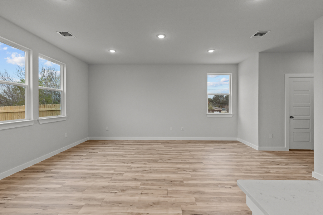 A room with a wood floor and windows.