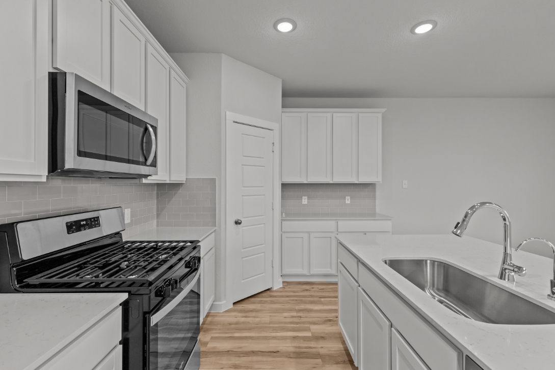 A kitchen with white cabinets.