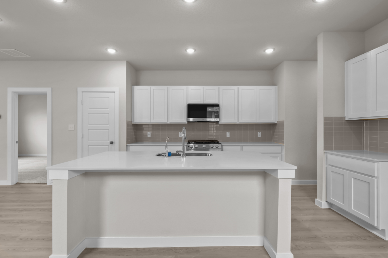 A kitchen with white cabinets.