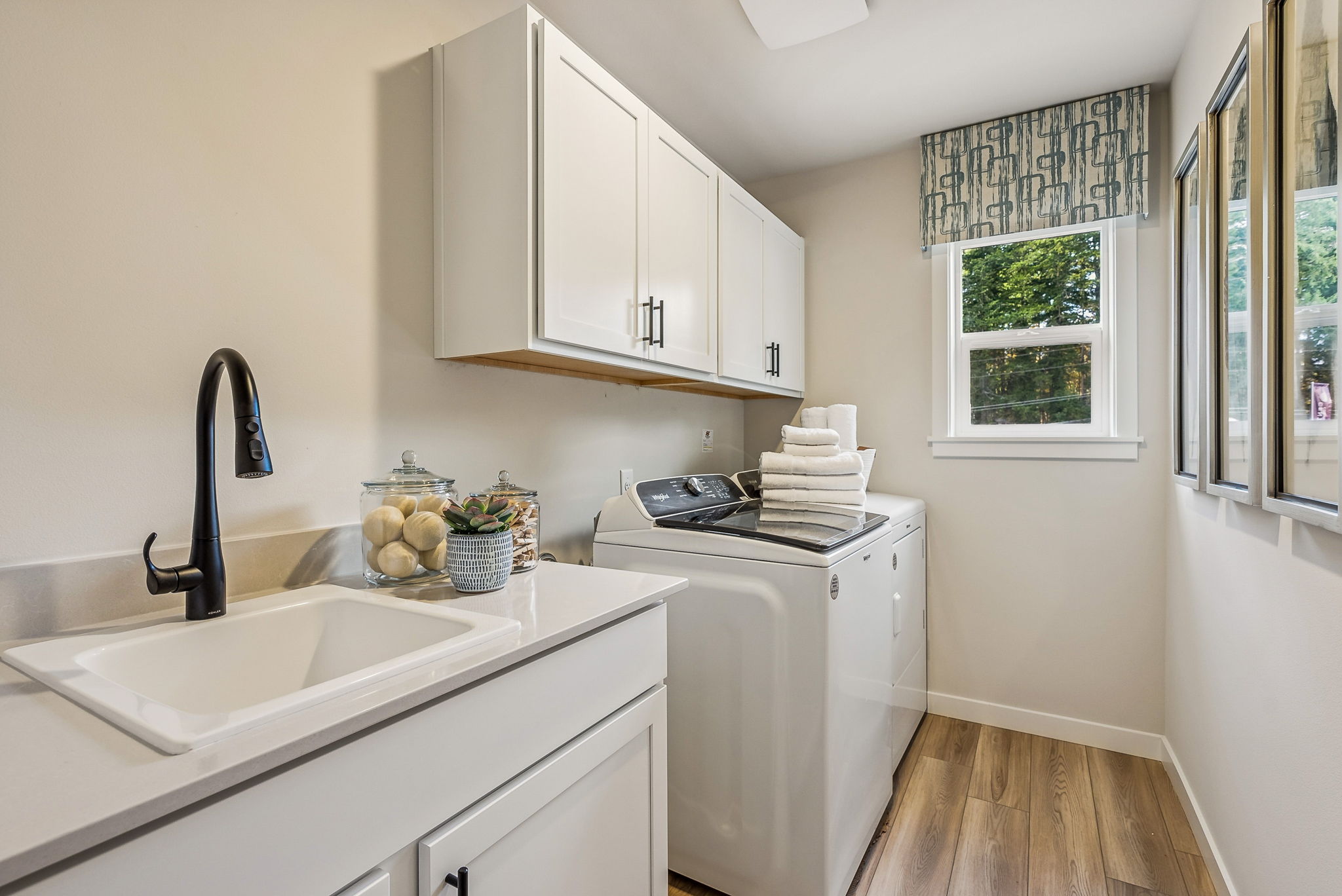 A kitchen with white cabinets.