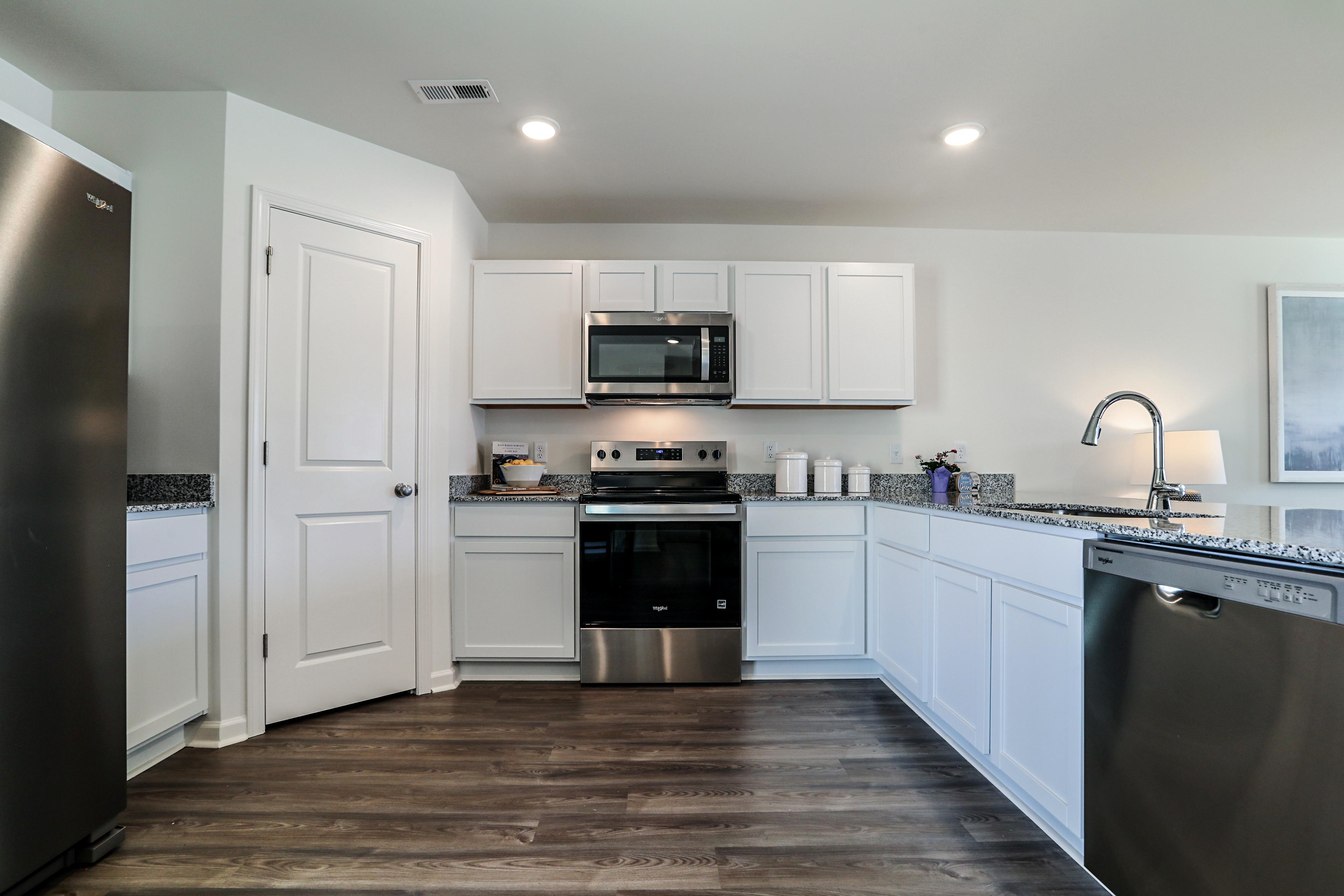 A kitchen with white cabinets.