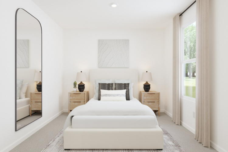 A bedroom with a white bed and white walls.