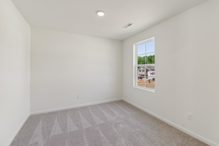 A room with a carpet and a window.