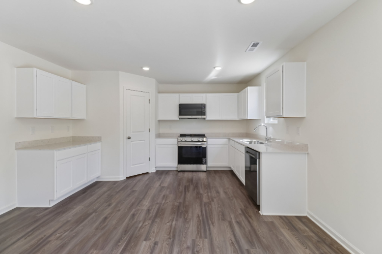 A kitchen with white cabinets.