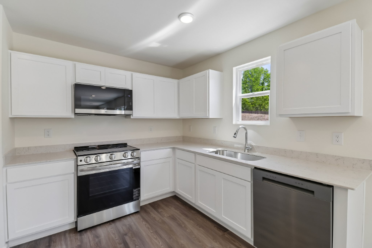 A kitchen with white cabinets.