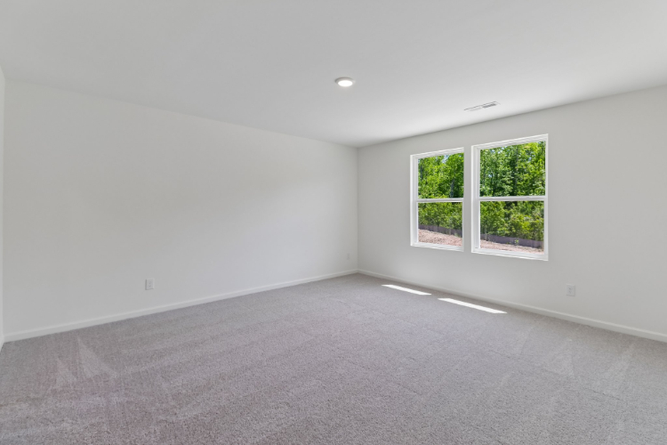 A room with a window and a white wall.