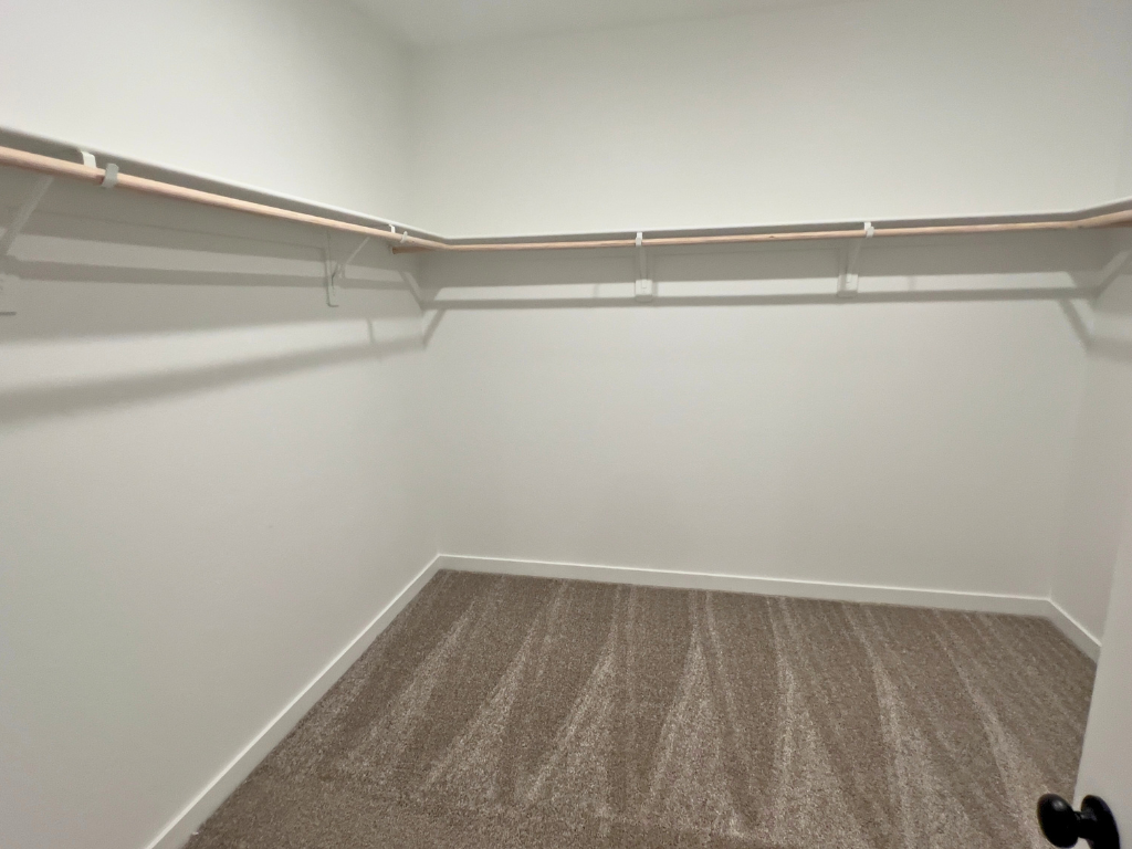 A white wall with a metal bar.
